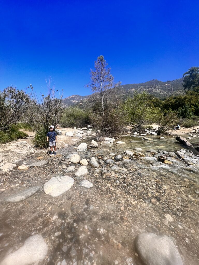 boy next to water stream