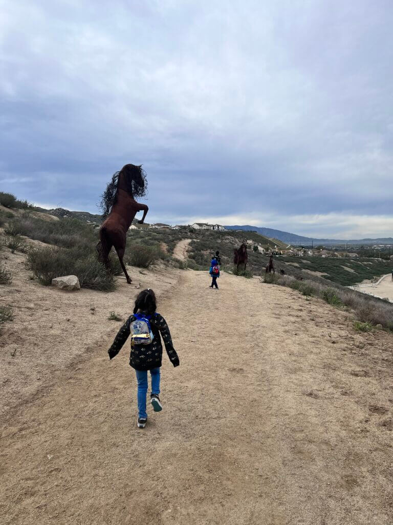 Kids next to horse statues