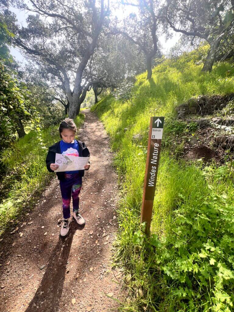 Girl next to trail marker